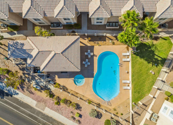 an aerial view of a swimming pool in front of a house