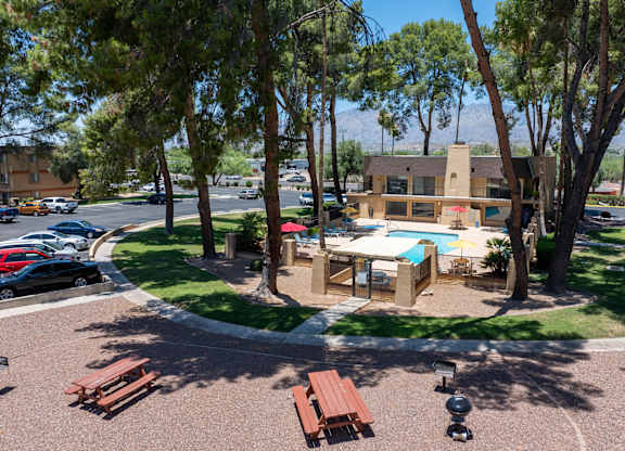 A sunny day at the park with picnic tables and a playground.