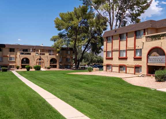 A large grassy area in front of a building with a pathway leading to it.