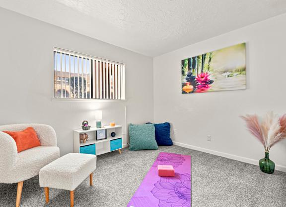 A room with a chair, a table, and a rug.