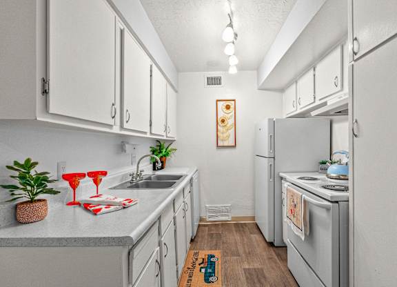 A kitchen with white cabinets and a grey counter top.