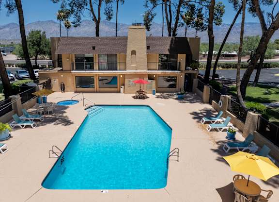 A large swimming pool surrounded by chairs and umbrellas.