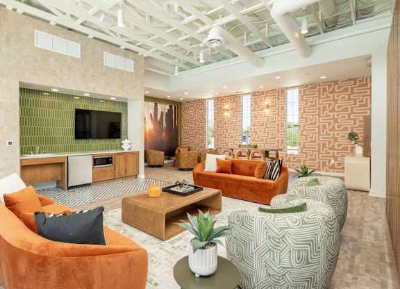 A living room with orange and green furniture and a flat screen TV.