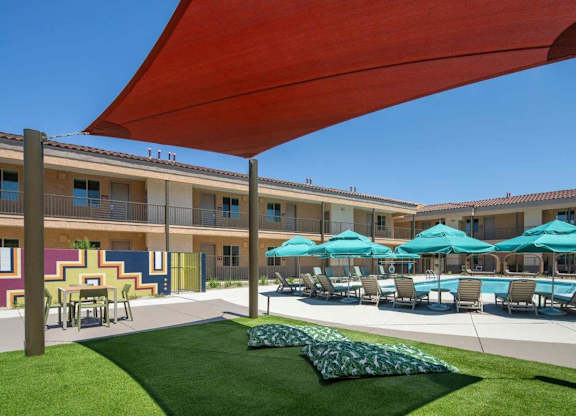 A large red shade structure is over a pool area.