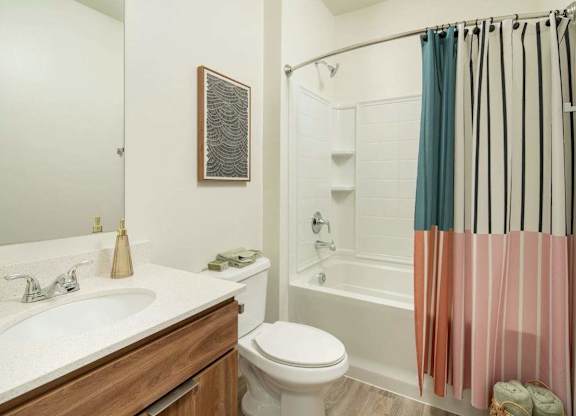 A bathroom with a toilet, sink, and shower.