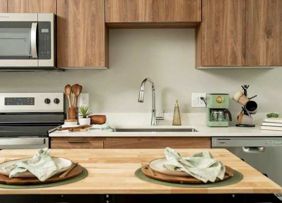 A kitchen with a wooden countertop and a stainless steel oven.