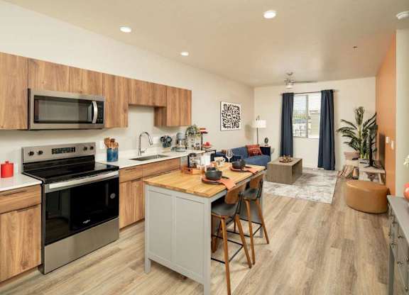 A modern kitchen with wooden cabinets and a grey island.