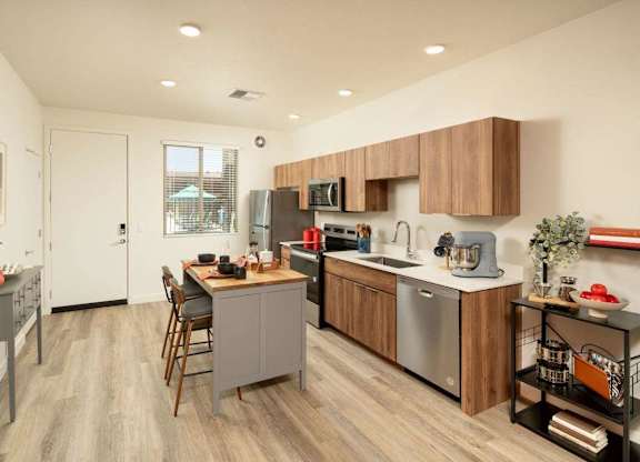 A modern kitchen with wooden cabinets and a grey island.