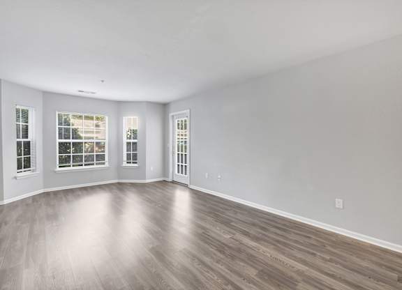 A spacious room with wooden flooring and three windows. at Ardenwood Apartments, North Haven