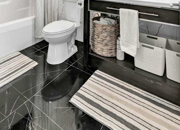 a bathroom with a toilet and a sink and a mirror at The Meriden, Connecticut, 06450