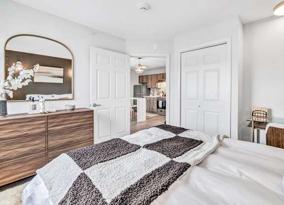 a bedroom with a bed and a kitchen in the background at The Meriden, Meriden, 06450