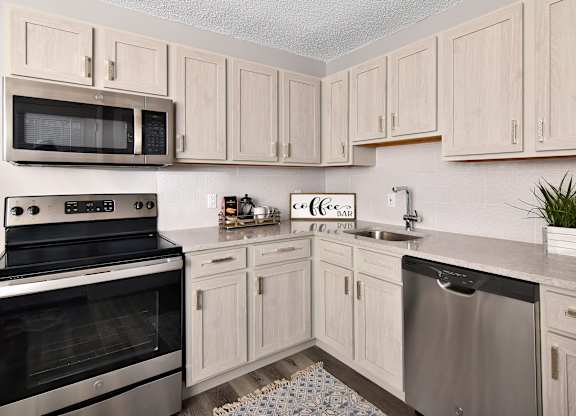 a kitchen with stainless steel appliances and white cabinets at Encore 99, East Haven, CT, 06512