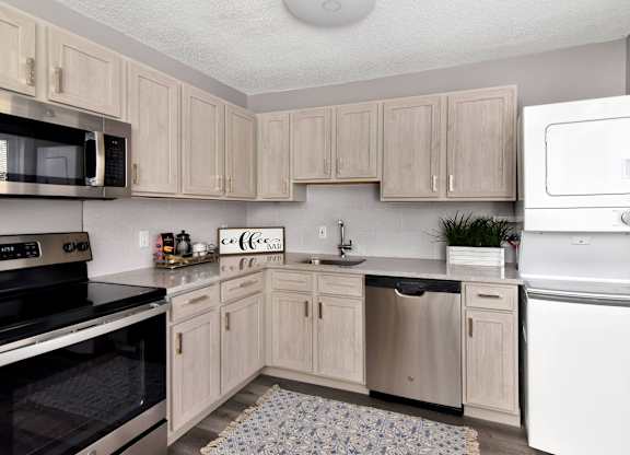 a kitchen with white appliances and wooden cabinets at Encore 99, East Haven, CT, 06512