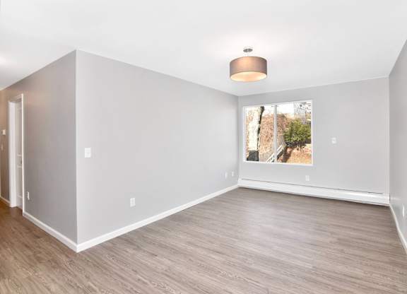 an empty living room with white walls and a window at Springwood Gardens, Connecticut