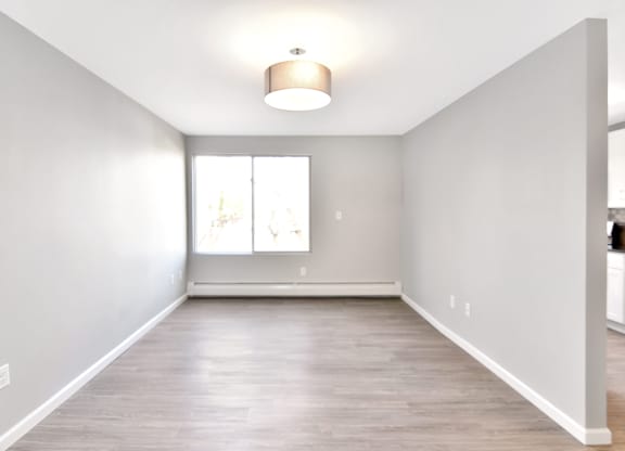 an empty living room with white walls and a window at Springwood Gardens, New Britain, CT