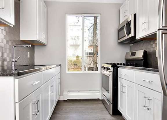 a white kitchen with white cabinets and a window at Springwood Gardens, New Britain