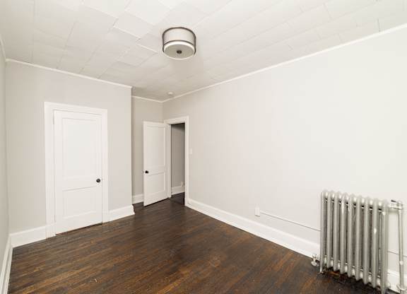 an empty room with a radiator and white walls at The Packard, West Hartford, CT, 06119