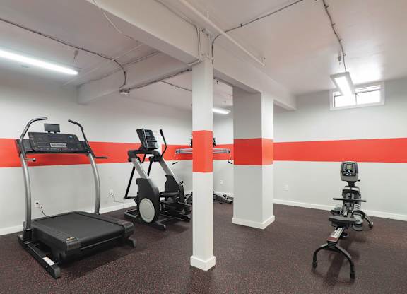 a gym with exercise equipment and a red stripe on the wall at The Packard, West Hartford, 06119