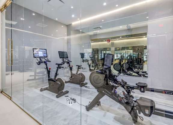 a gym with cardio equipment and glass walls at Up House, Connecticut