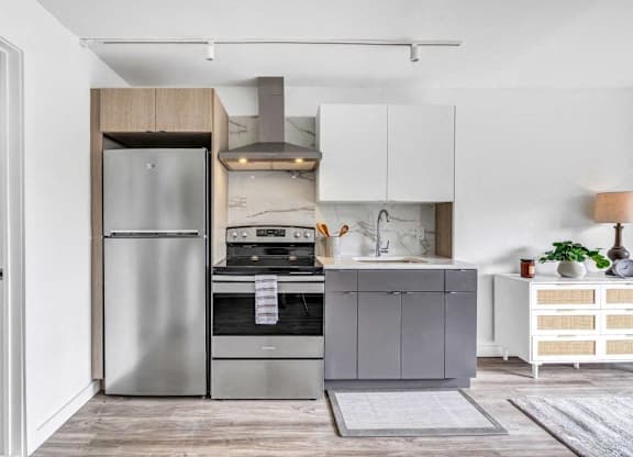 a small kitchen with stainless steel appliances and white cabinets at Up House, Farmington, 06032