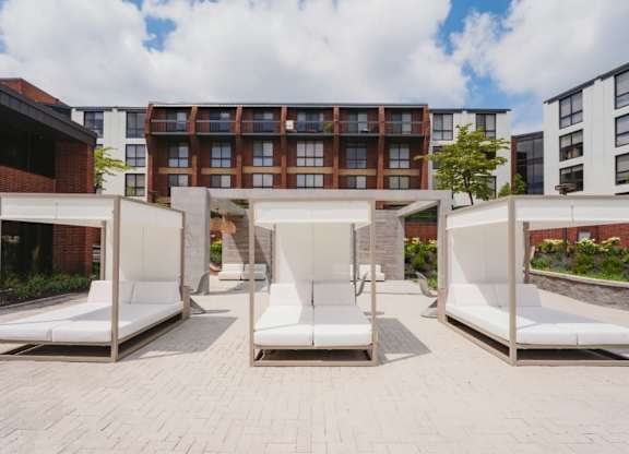 a seating area with white couches in front of a building at Up House, Farmington