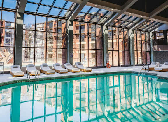 a swimming pool in front of a building with large windows at Up House, Connecticut, 06032
