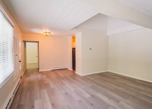 an empty living room with wood floors and a window at Woodbury Knoll, Woodbury, CT