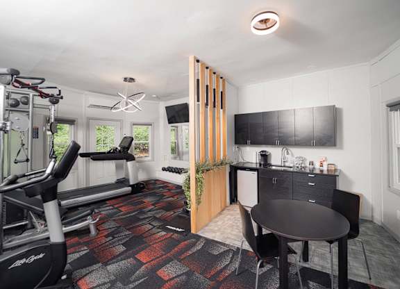 a workout room with a table and chair and a treadmill at Woodbury Knoll, Woodbury, CT