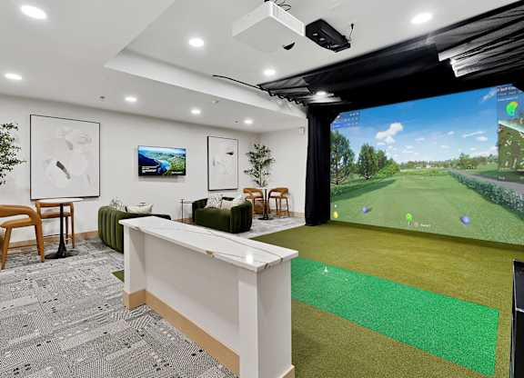 A room with a white reception desk and a large screen on the wall.