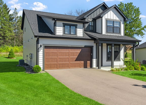 a house with a brown garage door in front of it