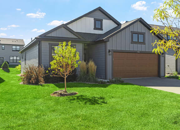 a home with a brown garage door and a green lawn