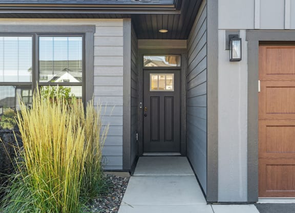 the front entrance of a house with a black door