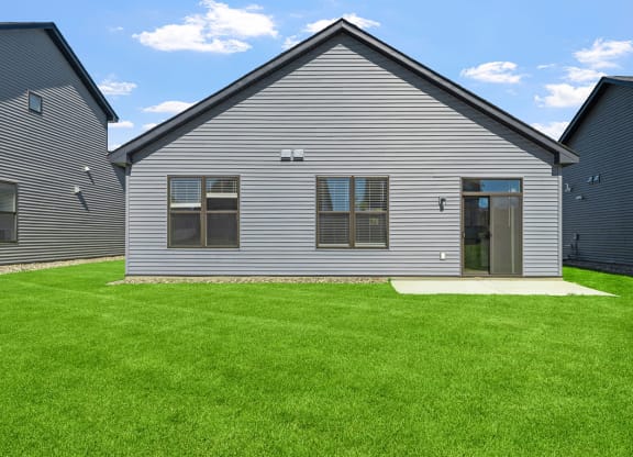 a renovated house with a yard in front of it