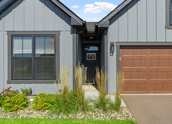 the front of a house with a garage door and