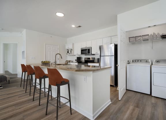 a kitchen with white appliances and a counter with stools