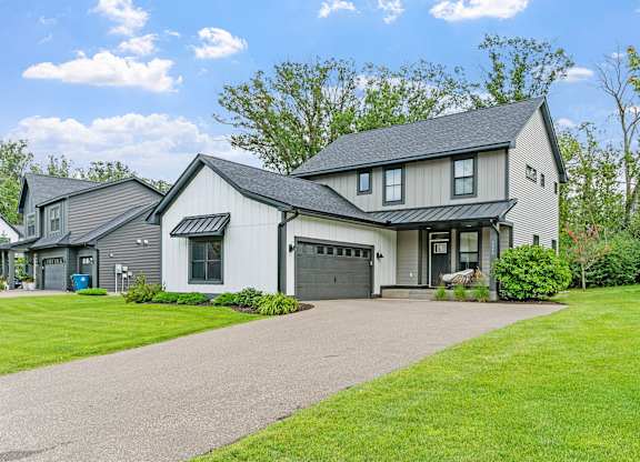 A large house with a driveway in front.