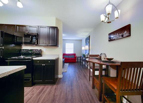 A kitchen with dark wood cabinets and a red couch.