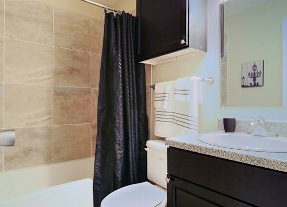 A bathroom with a black cabinet and a white toilet.