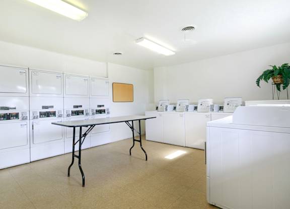 A laundry room with a table and washing machines.