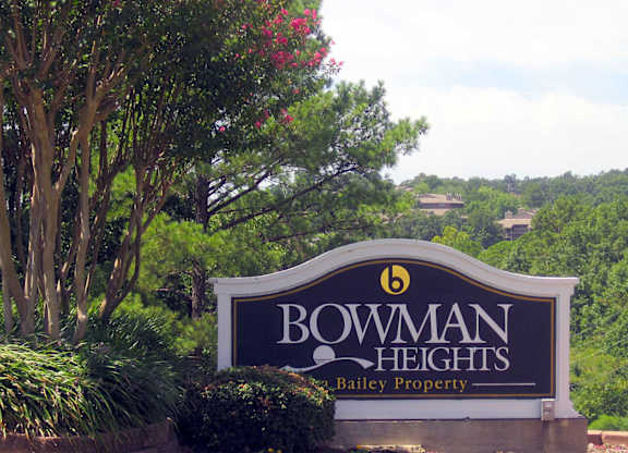 A sign for Bowman Heights in front of a green landscape.