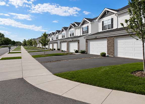 A row of houses with a sidewalk in front.
