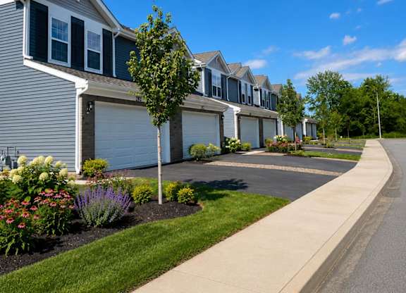 A row of houses with a sidewalk in front.