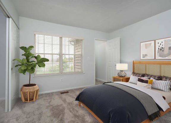 a bedroom with a bed and a potted plant