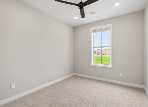 a bedroom with a ceiling fan and a window