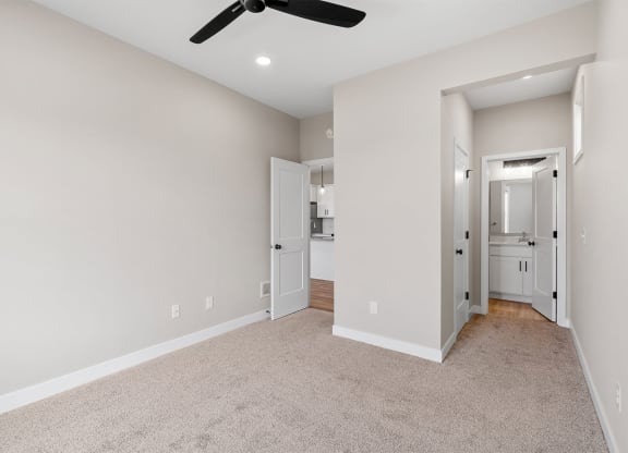 a bedroom with a ceiling fan and carpet