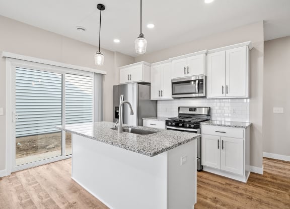 a kitchen with white cabinets and a granite counter top