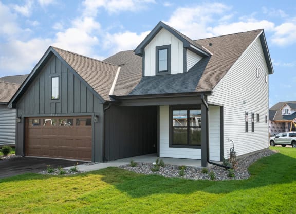 a house with a gray roof and a brown garage door