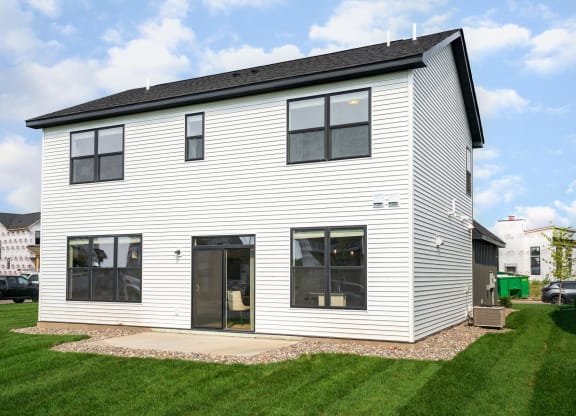 a home with white siding and a black roof