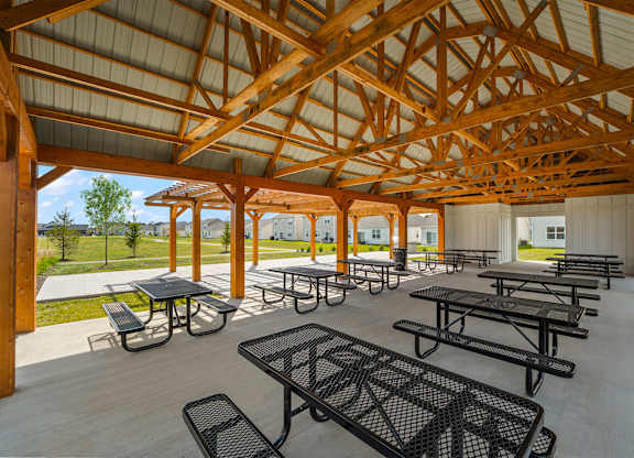 A wooden pavilion with tables and benches.