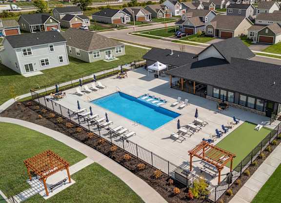 A large outdoor swimming pool surrounded by a deck and lounge chairs.